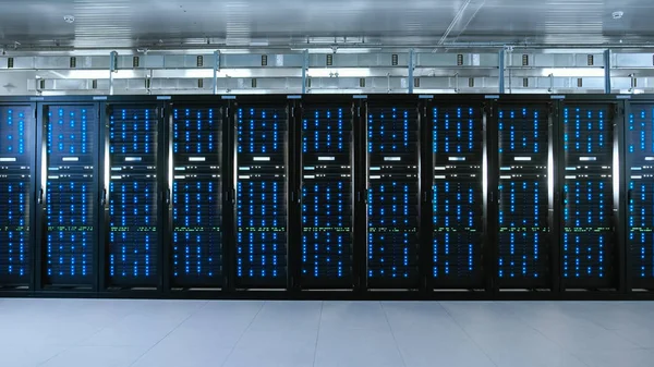 Tiro de un centro de datos de trabajo con filas de servidores en rack. Las luces led parpadean y las computadoras están funcionando . — Foto de Stock
