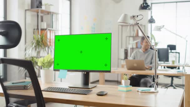 Computador Mock-up de mesa de tela em pé sobre a mesa no escritório criativo moderno. No Escritório Brilhante de Fundo onde a Equipe Diversa de Jovens Profissionais Trabalha em Computadores — Vídeo de Stock