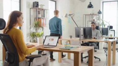 Omuz Over: kadın çalışan sosyal medya ağ sitesi aracılığıyla browsing, duvara tarama. Genç profesyoneller çeşitli ekip bilgisayarlarda çalışma ofis
