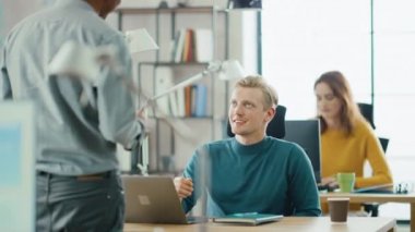 Yakışıklı Kafkas o uzman masasında oturan bir laptop çalışıyor, Hint Proje Yöneticisi ile tartışma var. Ofiste çalışan genç profesyoneller çeşitli ekibi