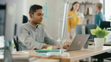 Akıllı ve yakışıklı Hintli ofis Işçisi onun masasında oturan bir laptop çalışır. Başarılı adam 