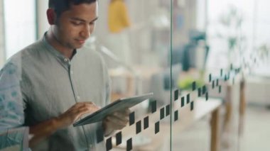 Yakışıklı profesyonel Hint adam portre dokunmatik ekran dijital tablet bilgisayar kullanır, önemli e-posta, Smiles charmingly yazar. Parlak farklı ofiste çalışan başarılı adam