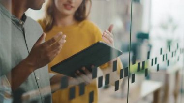 Portre yakışıklı Hint adam gösteren dokunmatik ekran dijital tablet bilgisayar Için onun güzel kadın takım üyesi, onlar tartışmak proje detayları. Farklı ofiste çalışan başarılı genç Insanlar