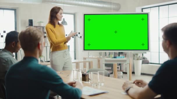 Vrouwelijke project manager houdt vergaderings presentatie voor een team van ontwikkel ontwikkelaars. Ze toont groen scherm interactief whiteboard-apparaat voor Business planning concept. Jonge mensen werken in creatief kantoor — Stockvideo