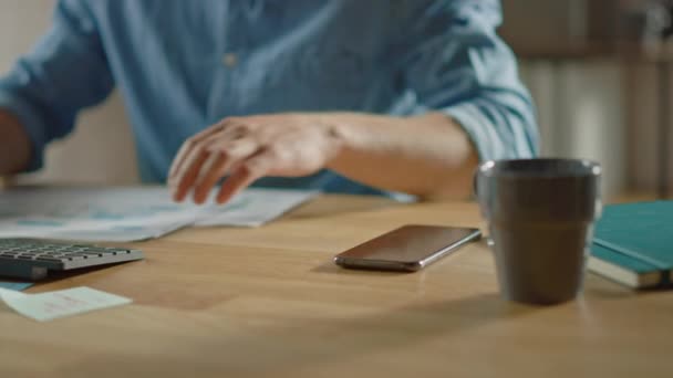 Üzletember ül az ő Desk működik asztali számítógép a stílusos irodában, felveszi és elindítja a smartphone, használja Social Media app, elektronikus levél üzleti partnerek, üzenetküldés. Fókuszban a kezek és a telefon — Stock videók