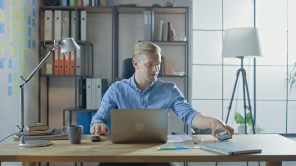 Entrepreneur Sitting at His Desk Works on Desktop Computer in the Stylish Office, Checks His Smartphone, Social Media App, email Business Associates, Messages — Stock Video