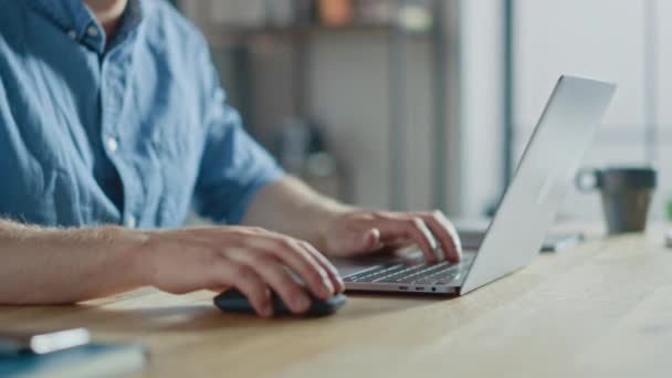 Empresario anónimo sentado en el escritorio de madera y trabajando en un ordenador portátil, escribiendo y escribiendo correo electrónico de negocios, diseñando software, navegando por Internet. Enfoque en las manos y el cuaderno — Vídeos de Stock