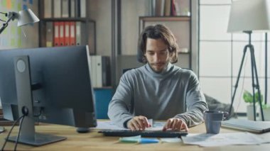 Moda Ofisi 'ndeki Masasında Oturan Yaratıcı Girişimci Masaüstü Bilgisayarı. Yakışıklı, Uzun Saçlı, Sanatsal Görünüşlü İspanyol Adam Bilgisayar Kullanıyor