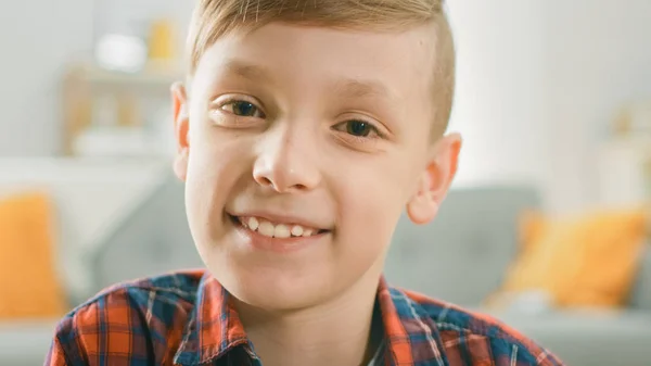 Portrait de Adorable jeune garçon souriant à la caméra. En arrière-plan chambre ensoleillée floue . — Photo