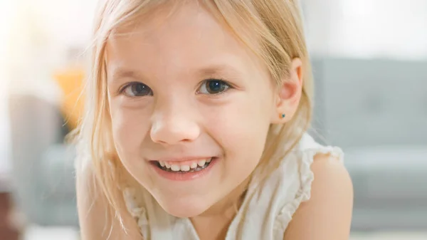 甜蜜可爱的快乐年轻的金发女孩在相机上微笑的肖像。在背景模糊的阳光房间. — 图库照片
