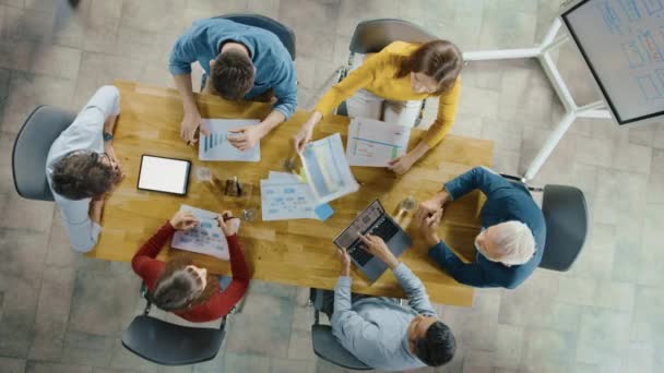 Sala de reuniones de inicio: Equipo de emprendedores sentados en la mesa de conferencias tienen discusiones, resolver problemas, utilizar tableta digital, ordenador portátil, compartir documentos con estadísticas, gráficos. Zoom de vista superior — Vídeos de Stock