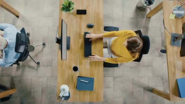 オフィスで撮影されたカメラのトップビューズーム デスクトップコンピュータで作業する彼女の机に座って美しい若い女性の専門家 プロフェッショナルが働く多様で近代的なオフィス — ストック動画