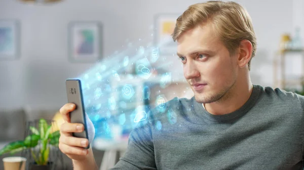 Visual Effect of Connecting and Surfing the Web with Illustrative Icons and Symbols. Handsome Young Man Uses Smartphone in His Living Room. Browsing in Internet and Social Networks, Relaxing at Home.