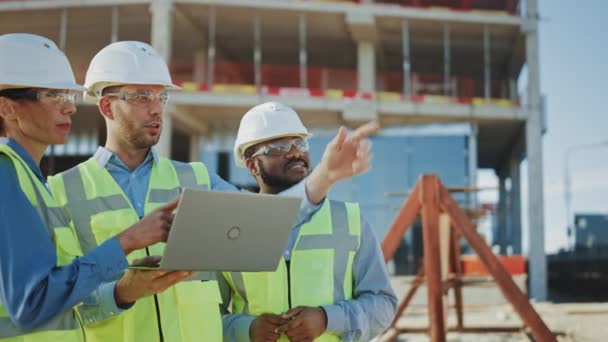 Equipe Diversa de Especialistas Usar Computador Laptop no canteiro de obras. Projeto de Construção Imobiliário com Engenheiro, Investidor e Empresária Área de Verificação, Trabalhando em Engenharia Civil, Estratégia de Discussão, Plano, Detalhes . — Vídeo de Stock