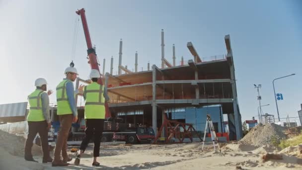 Diverse Team of Specialists Inspect Commercial, Industrial Building Construction Site. Real Estate Project with Civil Engineer, Investor and Businesswoman. In the Background Skyscraper Formwork Frames — Stock Video