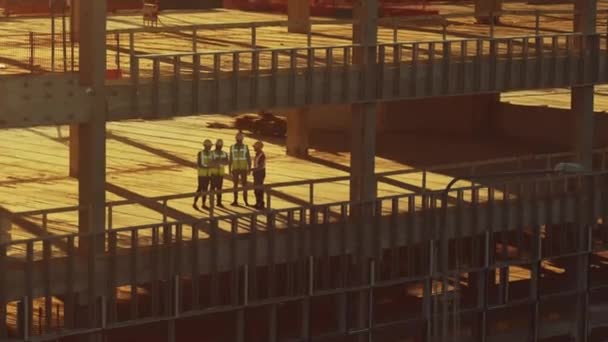 Luftaufnahme: Diversifiziertes Team von Spezialisten inspiziert Baustelle für Gewerbe-, Industrie- und Hochhausschalungen. Leitung des Immobilienprojekts durch Bauingenieur, Investor, Architekt und Arbeiter — Stockvideo