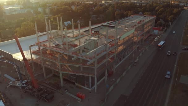 Luftaufnahme aufsteigend: Baustelle Industrie- / Gewerbeimmobilien. Maschinen und Wolkenkratzer Betonschalung mit im Sonnenaufgang — Stockvideo
