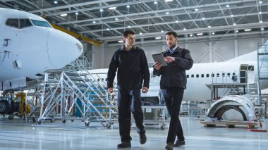 Takım uçak bakım mekaniğinin Hangar hareket. Tablet bilgisayar holding