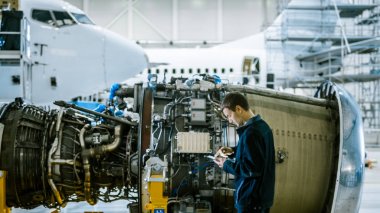 Uçak bakım makinist Inspecting ve hangarda Tablet uçak Jet motorunu kullanarak