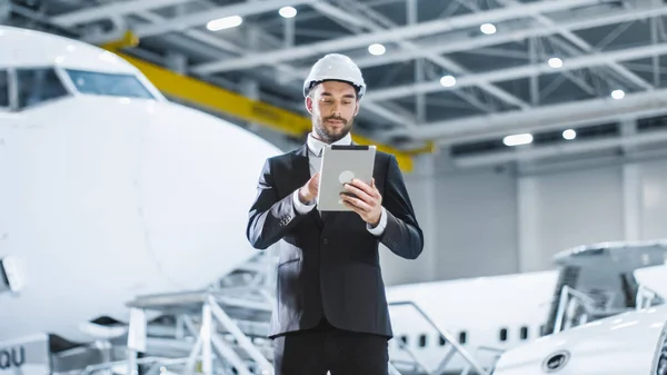 Geschäftsmann nutzt Tablet im Flugzeug-Wartungs-Terminal — Stockfoto