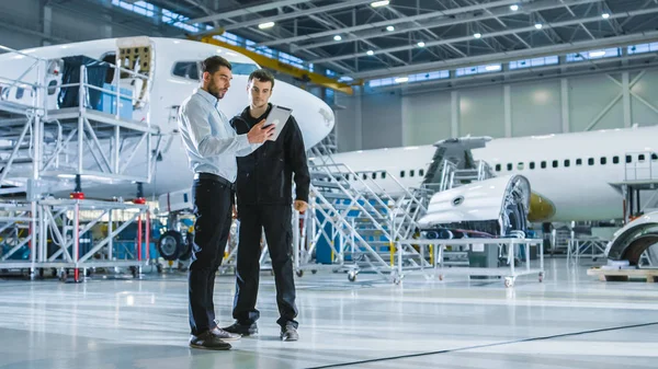 Trabajador e Ingeniero de Mantenimiento de Aeronaves conversando. Comprimido de retención . —  Fotos de Stock