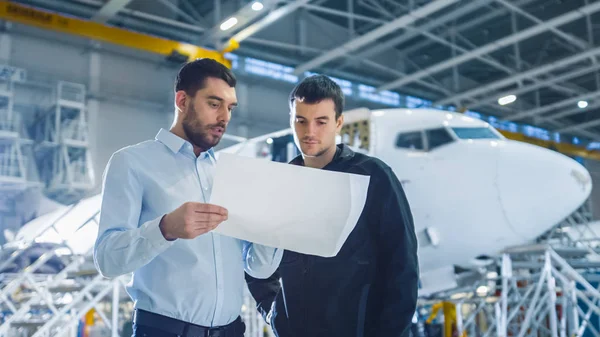 Vliegtuig onderhoud werknemer en ingenieur gesprek. Holding Project Blueprint. — Stockfoto