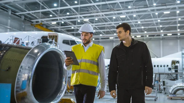 Team of Aircraft Maintenance Mechanics Moving through Hangar. Holding Tablet Computer — Stock Photo, Image