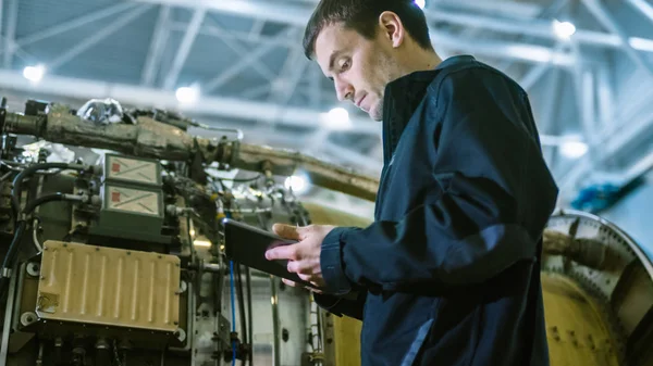 Mécanicien d'entretien des aéronefs Inspecter et travailler sur un réacteur d'avion dans un hangar — Photo