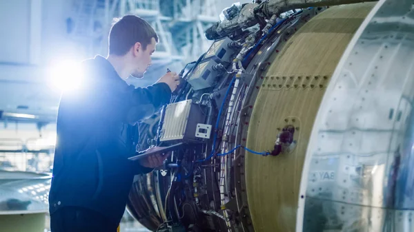 Repülőgép karbantartás szerelő vizsgálatával, és dolgozik a repülőgép sugárhajtómű hangárban — Stock Fotó
