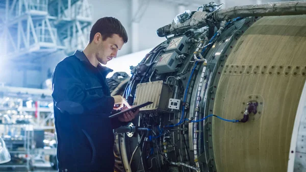 Mécanicien d'entretien des aéronefs Inspecter et travailler sur un réacteur d'avion dans un hangar — Photo