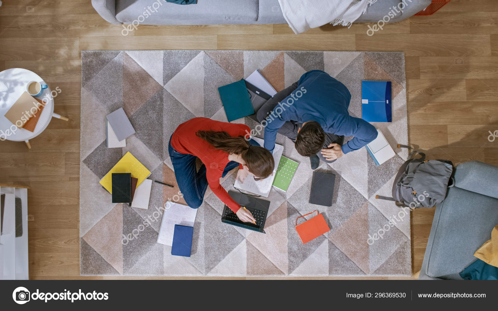 Young Couple Is Sitting On A Floor Working Or Studying On A