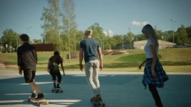 Dört Cool Genç Kızlar ve Çocuklar Sürme Longboard ve Kaykay Şehrin Şık Hipster Bölümü ile. Post Sanayi Mahallesinde Kaykay Yaparken Eğlenen Çekici Gençler