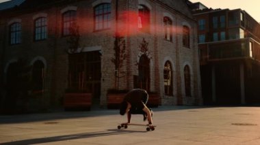 Çevik Profesyonel Patenci Onun Kaykay Eller üzerinde duruyor. Güçlü Adam Longboard'da El Standı Numaraları Yapıyor. Arka Planda Moda Hipster City District Street