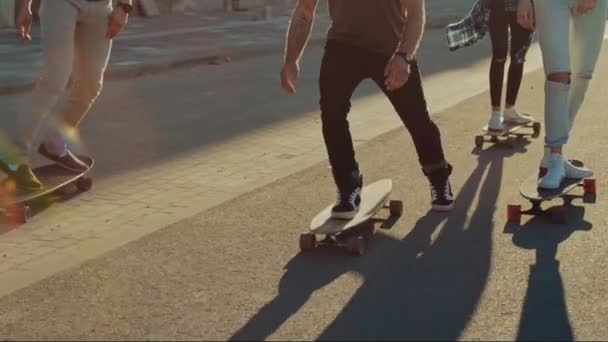 Skupina dívek a chlapců na Skateboarcích přes módní okres Hipster. Krásní mladí skateboarding přes moderní stylovou městskou ulici. Přesunutí kamery pro pomalé pohyby zaostřily na nohy — Stock video