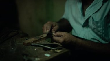 Otantik El Sanatları Takı Master Onun Atölyesinde bir Rasp / Grater ile Son Vuruş yapıyor Yeni Bir Orijinal Ürün Üzerinde Çalışıyor. Ellerde Yakın Çekim