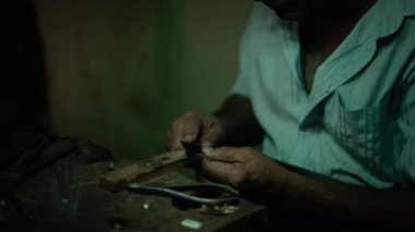 Otantik El Sanatları Takı Master Onun Atölyesinde bir Rasp / Grater ile Son Vuruş yapıyor Yeni Bir Orijinal Ürün Üzerinde Çalışıyor. Ellerde Yakın Çekim