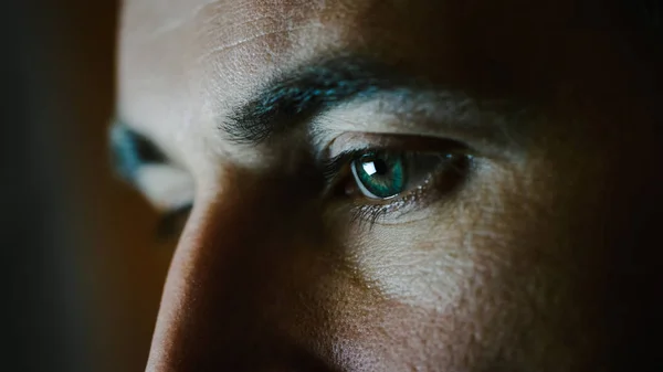 Primer plano de los ojos de un hombre verde-azul con la pantalla reflejándose en ellos . —  Fotos de Stock