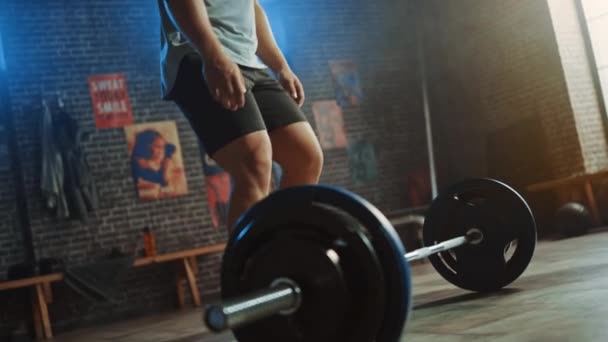 Hombre Muscular Guapo Hace Sobrecarga Deadlift con una barra en un pequeño gimnasio auténtico. Athletic Man Training His Arm Muscles and Exercises with Barbell (en inglés). Entrenamiento en el gimnasio Hardcore. Luz cálida . — Vídeos de Stock