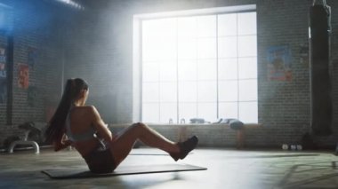 Spor Top Güçlü ve Fit Güzel Atletik Kadın Motivasyonposterler ile Bir Loft Style Sanayi Spor Salonu'nda Ball ile Core ve Ab Egzersizleri yapıyor. Onun Cross Fitness Eğitim Egzersiz Parçası.