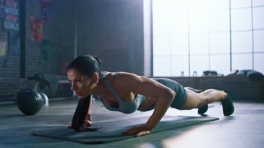Spor Top ve Şort Güçlü ve Fit Atletik Kadın Motivasyonposterler ile Bir Loft Style Sanayi Spor Salonu'nda Egzersizleri Push Up yapıyor. Onun Cross Fitness Eğitim Egzersiz Parçası.