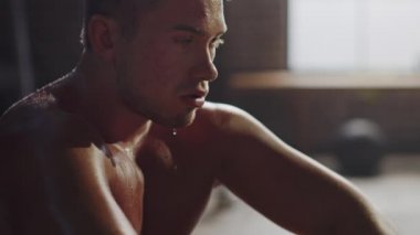 Güçlü Yakışıklı Fit Gömleksiz Adam Motivasyonposterler ile Bir Loft Sanayi Spor Salonu'nda Oturan. O Yoğun Fitness Eğitim Egzersiz sonra Nefesini Yakalamak's. Vücudunun her yerinde ter.