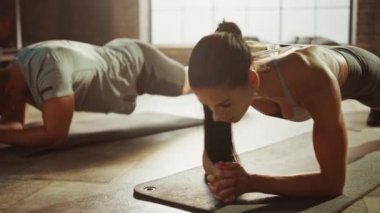 Güçlü Erkeksi Erkek ve İki Fit Atletic Kadın Onların Çekirdek Gücü Egzersiz Için Bir Tahta Pozisyon Tutun. Sarışın Kız Yorgun ve Eğitim İlk Fails. Onlar Bir Loft Spor Salonunda Egzersiz.