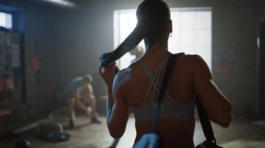 Hardcore Spor Salonu'na Güzel Atletik Womanwalking Shot ardından, Onun Arkadaşlar ve Diğer Sporcular Selamlıyor. Onun Güç Egzersiz, Güç Egzersiz ve Vücut Geliştirme Eğitim Oturumu için hazır