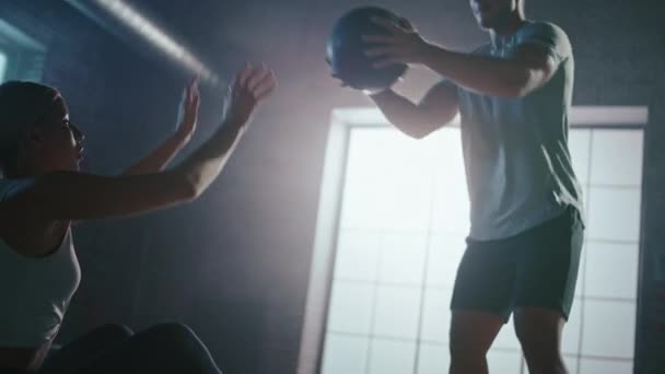 Beaux exercices de jeune fille avec entraîneur personnel, faire des sit-ups avec Medicine Ball, jeter passer en arrière et en avant. Fit et forte séance d'entraînement en couple. Exercice de force, de cardio et de puissance. Mouvement lent — Video