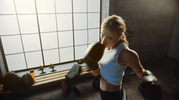 Professionele vrouwelijke bokser oefent Luchtstoten uit en draagt sportkleding en vecht handschoenen in de hardcore Gym. Sterk mooi meisje Kickboxing en Self Defense workout. Staand naar boven weergeven — Stockvideo