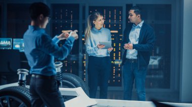 Otomotiv Tasarım Mühendisi ve Tablet ile Bilim Adamı Elektrikli Otomobil Şasi Prototiptartışmak. Yenilik Laboratuvarı Nda Tesis Konsept Araç Çerçevesi Tekerlekler, Süspansiyon, Motor ve Akü