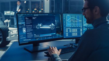 Profesyonel Mühendis 3d Cad Yazılımı ile Bir Bilgisayarda Çalışır ve Yüksek Teknoloji Geliştirme Laboratuvarı'nda Tekerlekler, Piller ve Motor Ayakta Elektrikli Araba Şasi Prototip Testleri.