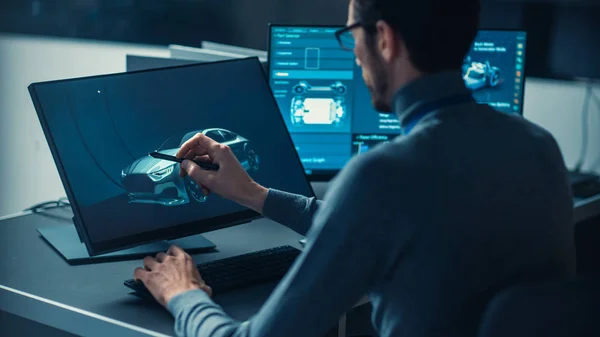 Professionele Automotive Graphic Designer werkt aan concept auto render met een stylus pen in een hightech innovatief laboratorium met een prototype auto chassis. — Stockfoto