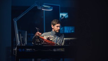 Gözlük ve Muayene Araçlarında Profesyonel Otomotiv Mühendisi, Kullanılmış Elektrikli Motoru Gece Yüksek Teknoloji Laboratuvarında Test Ediyor.