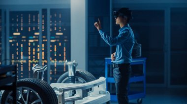 Elektrikli Oto Şasi PlatformuNda Çalışan Otomotiv Mühendisi, Dokunaklı Hareketlerle Artırılmış Gerçeklik Kulaklığı Kullanıyor. İnovasyon Laboratuvarı Nda Tesis Konsept Araç Çerçevesi Tekerlekli.